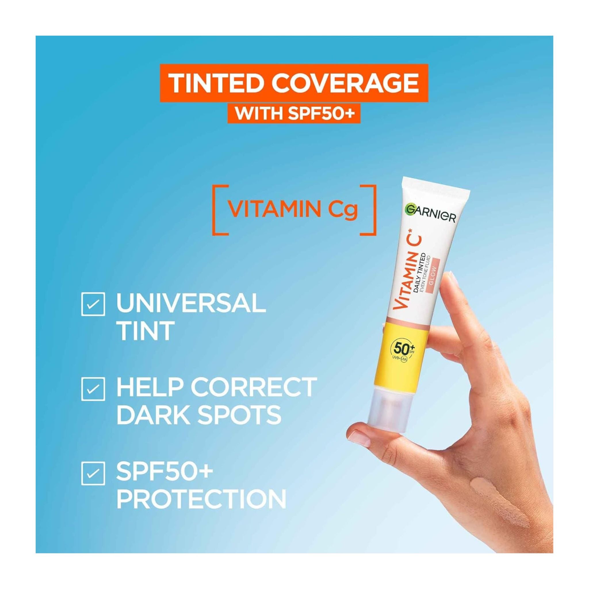 Garnier Vitamin C sunscreen tube with hand holding it against a blue background
