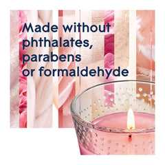 Candle in a glass holder with text about ingredients on a pink floral background