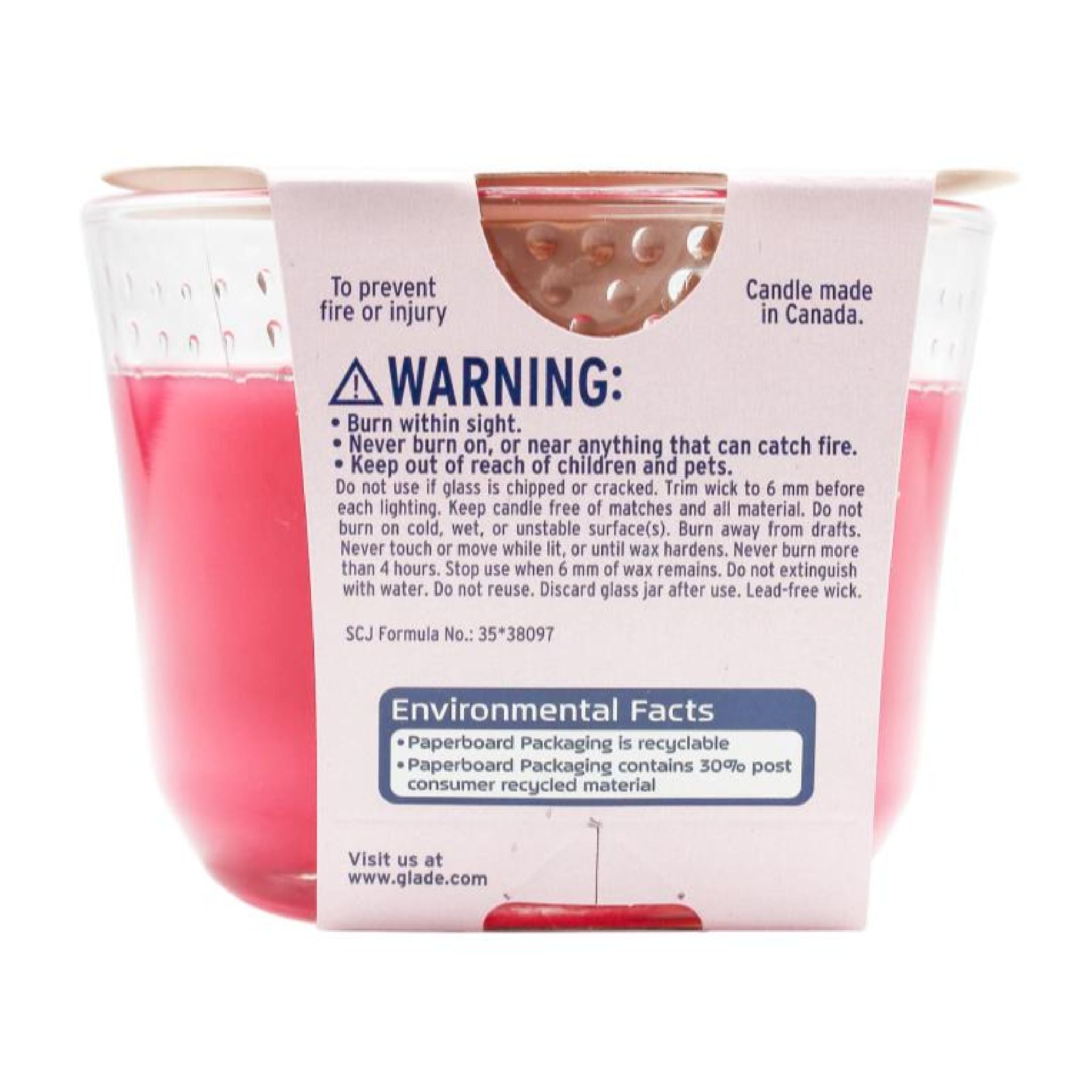 Pink candle in a glass jar with warning label on a white background