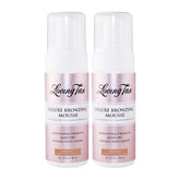 Two bottles of Loving Tan Deluxe Bronzing Mousse on a white background