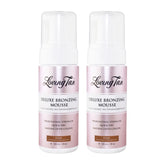 Two bottles of Loving Tan Deluxe Bronzing Mousse on a white background