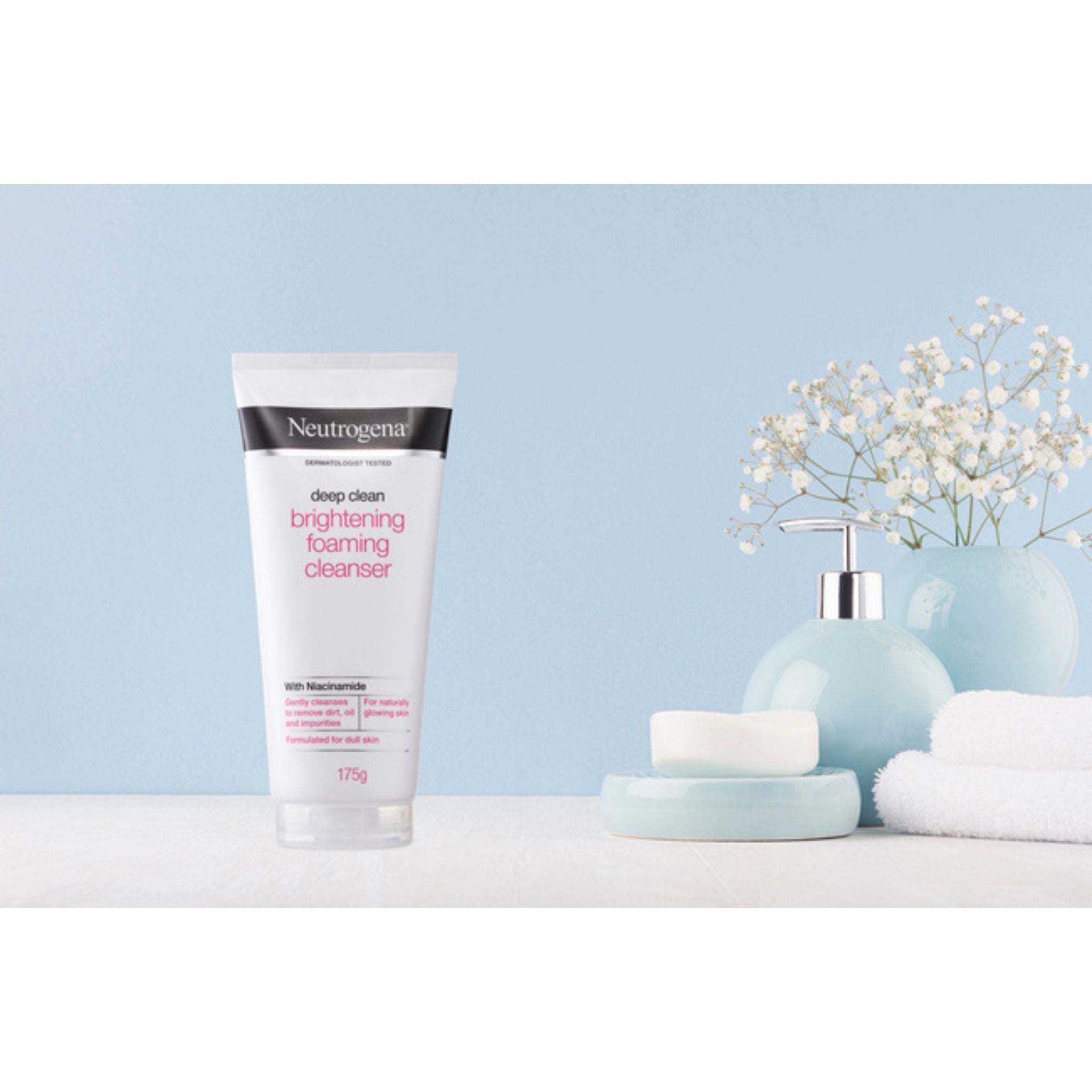 Neutrogena Brightening Foaming Cleanser displayed in a spa setting with flowers and folded towels