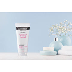 Neutrogena Brightening Foaming Cleanser displayed in a spa setting with flowers and folded towels