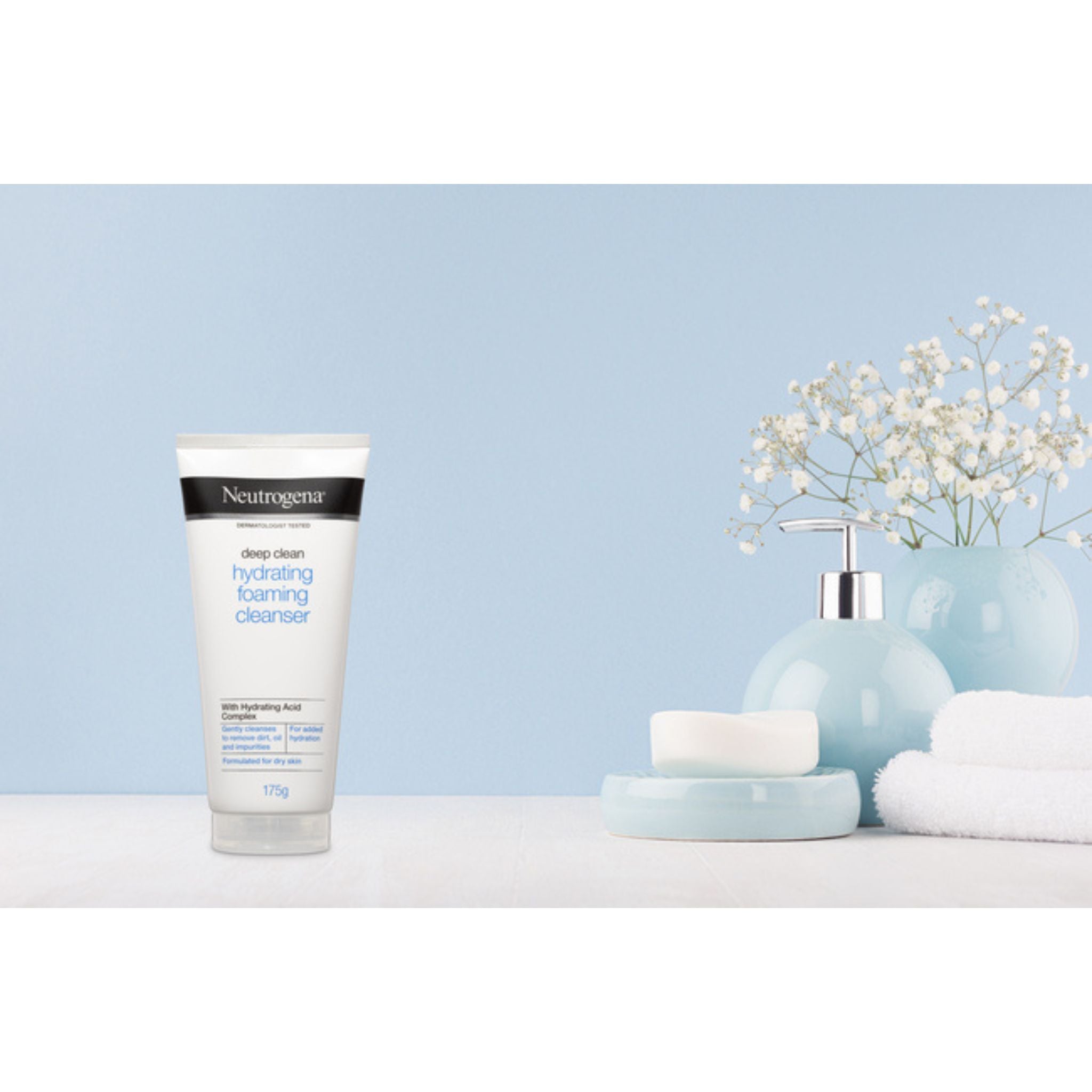 Neutrogena Deep Clean Foaming Cleanser displayed with flowers and towels in a spa-like setting