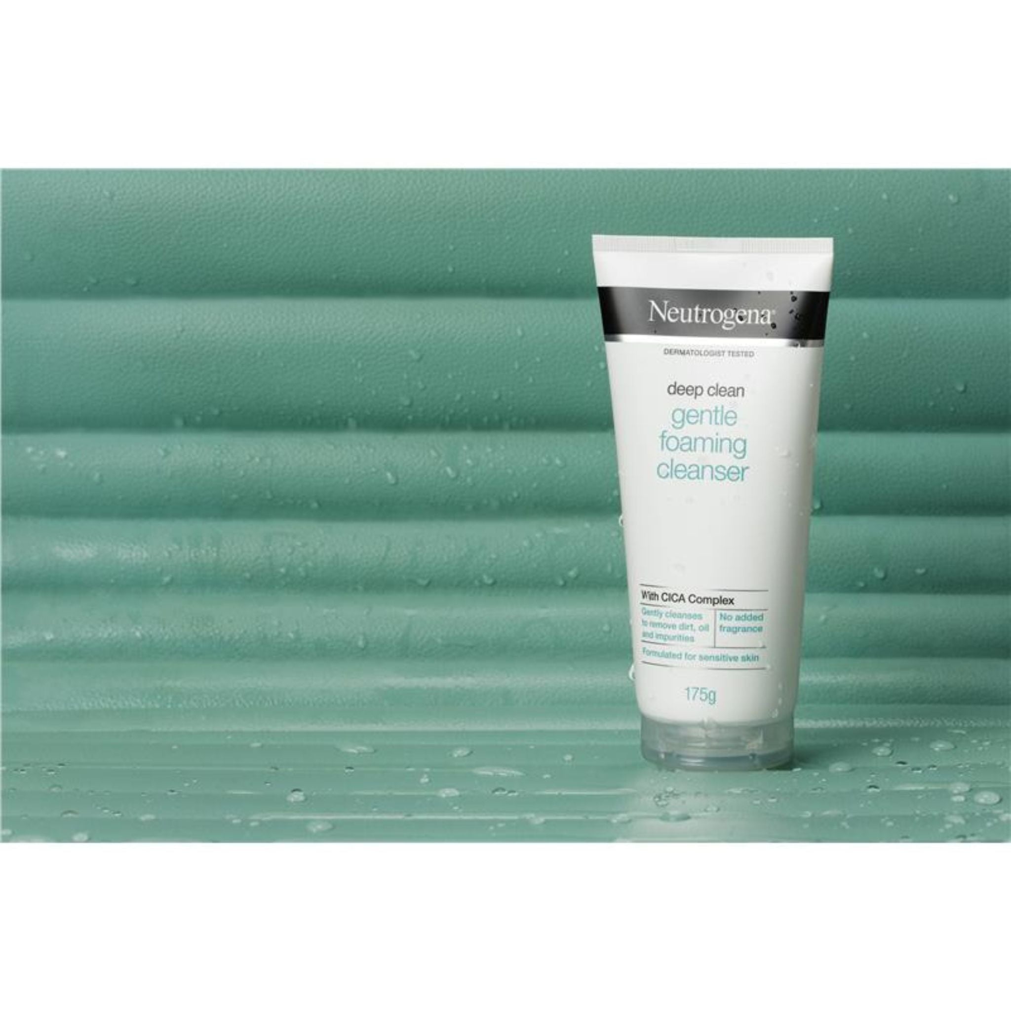 Neutrogena Gentle Foaming Cleanser tube standing on a green surface for a clean, minimalist aesthetic