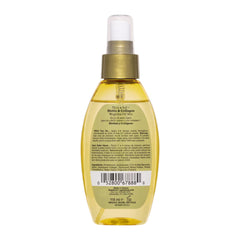 Bottle of hair oil with a gold cap on a white background
