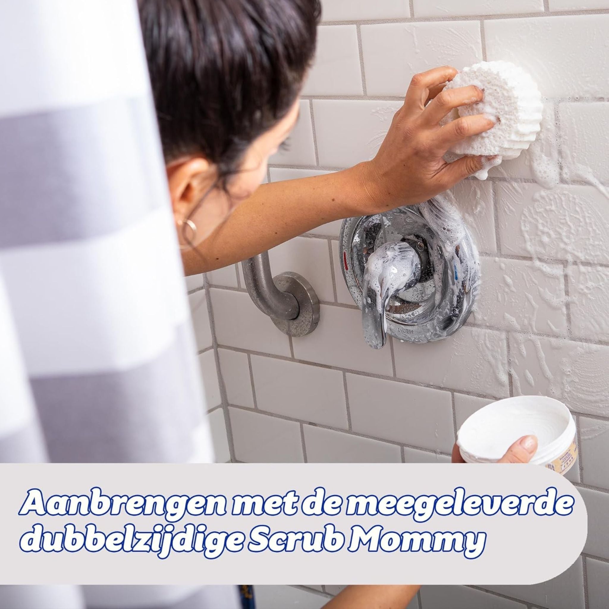 Woman using Scrub Mommy and Power Paste to clean tiled bathroom shower wall
