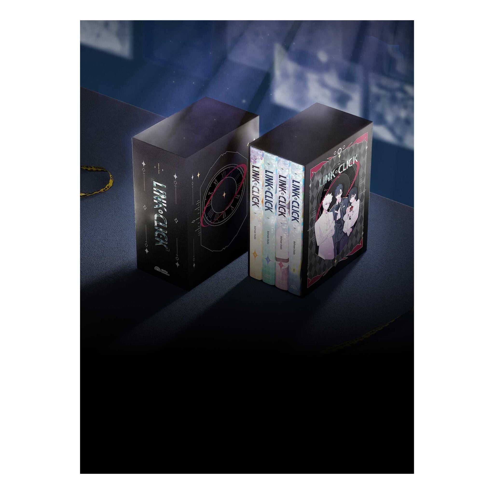 A boxed set for the anime 'Love, Deeper Love' shown on a dark tabletop with a blue-toned background. The set includes a tall black outer box with white and red line-art graphics, a smaller black box displaying the book spines, and a gold keychain hanging to the left.