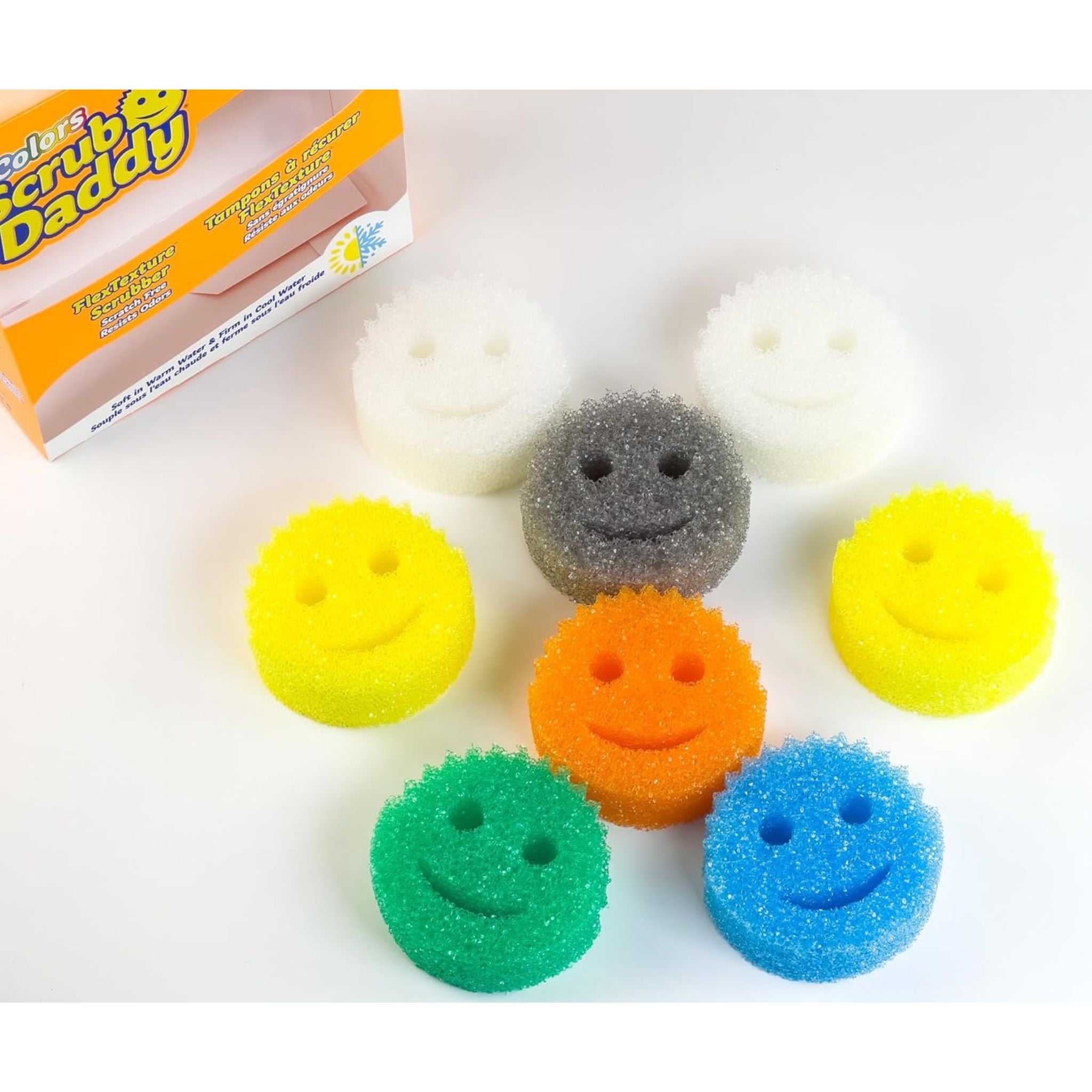 Set of smiley face sponges in various colors with Scrub Daddy packaging in the background.