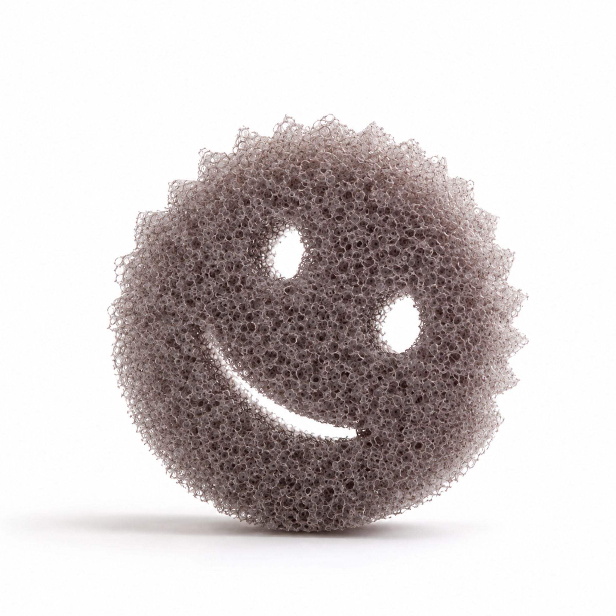 A round, textured gray sponge with a smiley face cutout, shown on a clean white background.