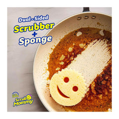 Scrub Daddy scrubber with smiley face design on a rusty pan, featuring the brand name 'Scrub Mommy'.
